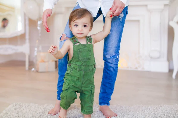 The boy sits on the carpet on the floor and next to him the dog toy Terrier — Stock Photo, Image