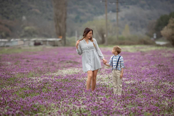 Belle maman tient sa main fils sur une promenade — Photo