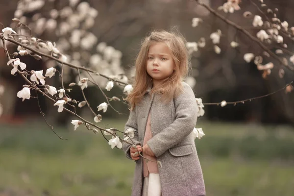 Ett barn i bakgrunden av blommande vita träd — Stockfoto