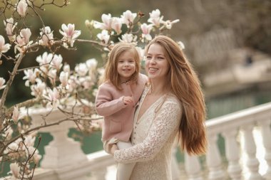 Parkta kızı olan bir kadın. Annem yürürken sevgili kızına sarılır ve onu kucaklar.