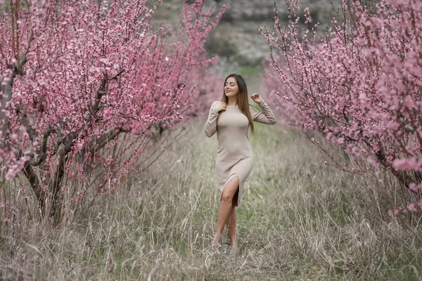 Eine Frau genießt die Einheit mit der Natur in einem blühenden Garten — Stockfoto
