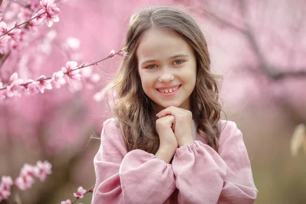 Ritratto di ragazza contro un albero in fiore rosa — Foto Stock