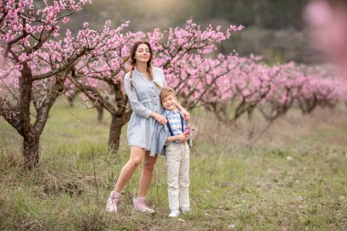 Anne ve çocuk baharda çiçek bahçesinde