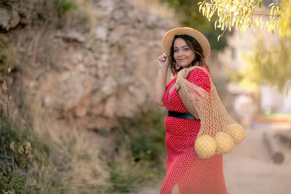Woman carries ripe fruit in shopping bag