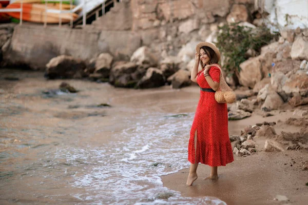 Tourist σε κόκκινο φόρεμα βόλτες σε υγρή άμμο — Φωτογραφία Αρχείου