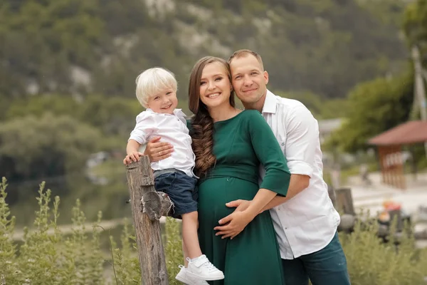 Eine dreiköpfige Familie steht an einem Holzzaun im Dorf — Stockfoto