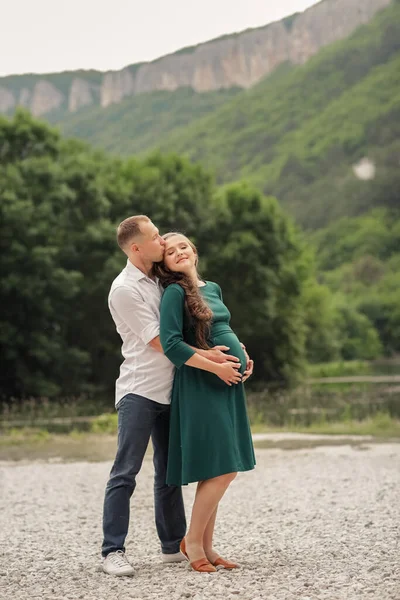 Homme câlins femme enceinte au milieu des montagnes et des lacs — Photo