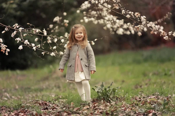 Flicka 3-4 år gamla sniffar blommor av blommande träd — Stockfoto