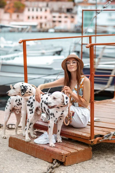Mädchen spaziert mit Haustier, erwachsene Dalmatiner am Wasser mit Wassertransport. — Stockfoto