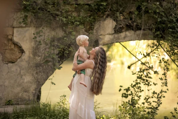 Женщина с ребенком гуляет по лесу на озере реки — стоковое фото