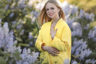 Etrafı leylak çiçekleriyle çevrili genç bir kız