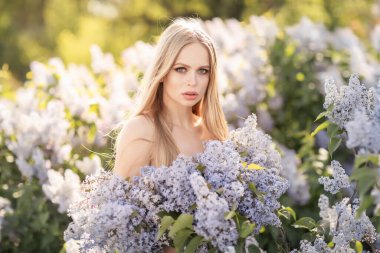 Etrafı leylak çiçekleriyle çevrili genç bir kız