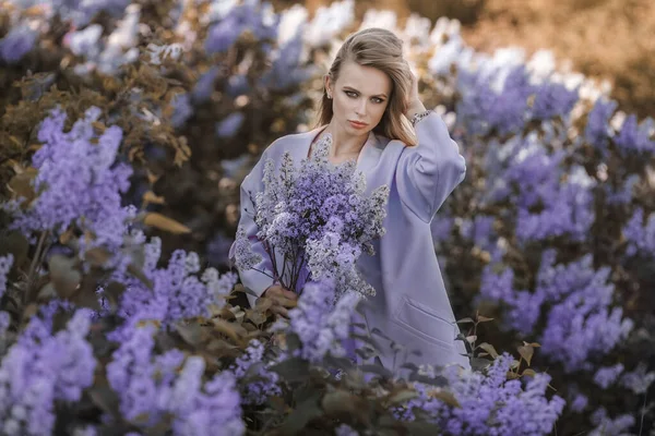 Una joven rodeada de flores lila —  Fotos de Stock