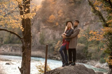 Bir çift kadın ve erkek birlikte yürür ve kucaklaşırlar.