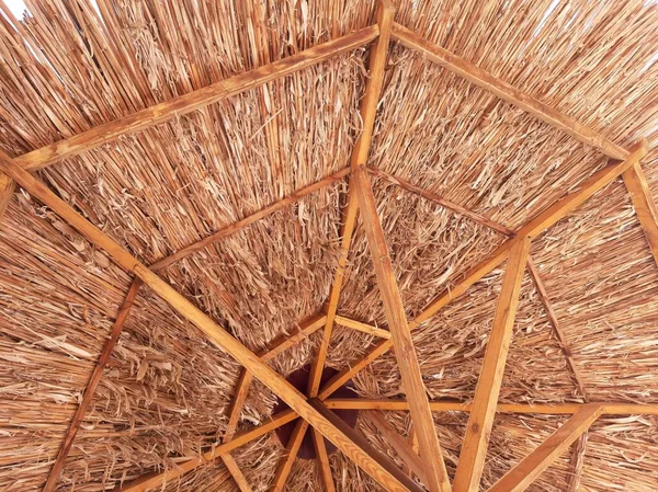 A projection of a straw canopy against a blue sky