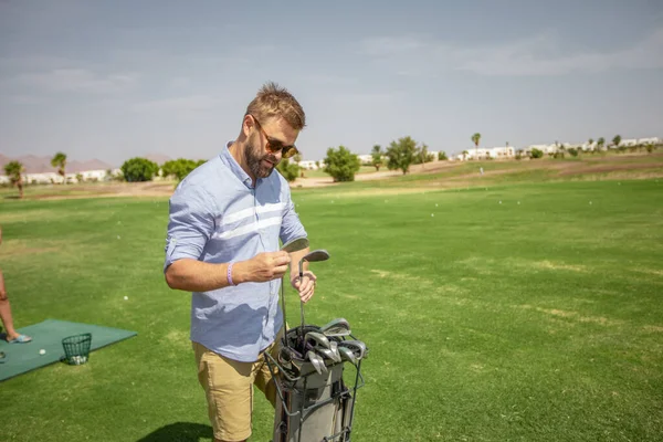 골프 코스에 있는 한 남자 가장비를 검사하고 골프클럽에서 열리는 스포츠 행사를 준비 한다 — 스톡 사진