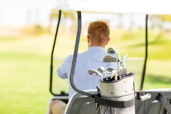 Un hombre monta un campo de golf en un carrito de golf — Foto de Stock