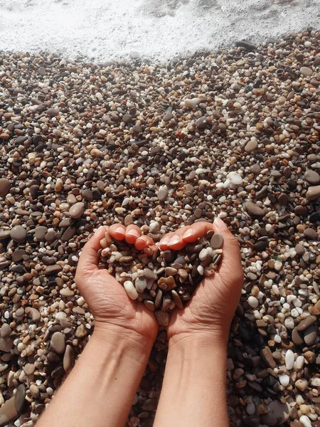 Una mano di uomo tiene una manciata di pietre — Foto Stock