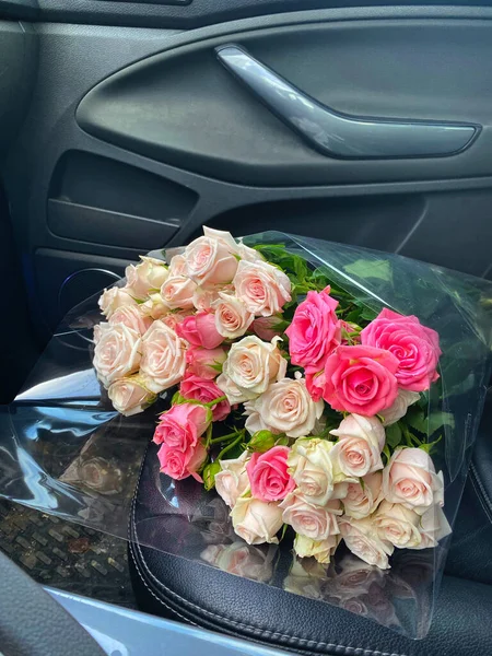 En bukett med blomster fra rosene i forsetet på bilen – stockfoto