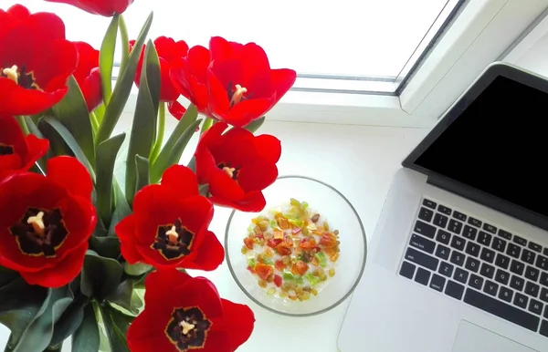 Flores com um laptop close-up no local de trabalho — Fotografia de Stock