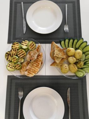 Pişmiş patates, sebze ve kızarmış ekmek. Izgara tavuklu fileto ile ızgara kabak