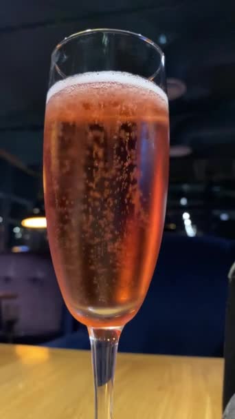 A glass of cold champagne close-up against a dark background — Stock Video