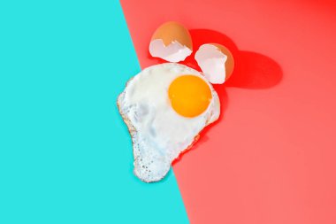 Kırık kabuklardan kaynaklanan çırpılmış yumurta mercan ve turkuaz arka planda