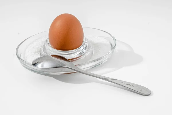 Cam tezgahta rafadan yumurta ve beyaz arka planda kaba tuz.