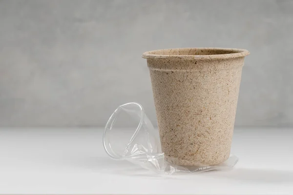 Kırışmış plastik bardakta duran tek kullanımlık kağıt bardak.