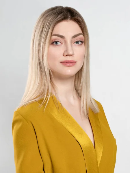 Beyaz arka planda sarı ceketli sarışın kız.