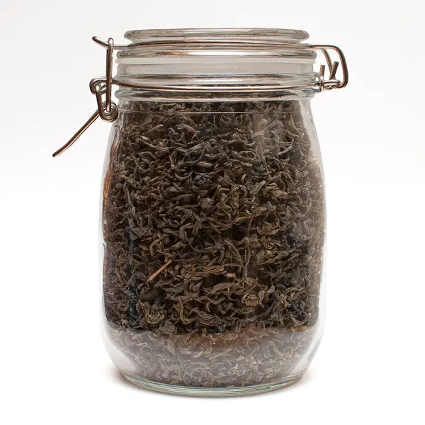 Beyaz üzerine izole edilmiş çay yapraklı cam kavanoz