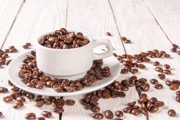 Кофе фасоль в чашке на столе — стоковое фото