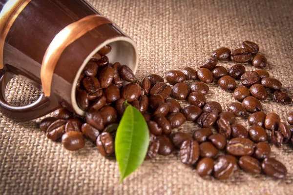 Кофейные зерна, выливающиеся из чашки — стоковое фото