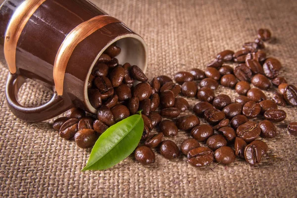 Кофейные зерна, выливающиеся из чашки — стоковое фото