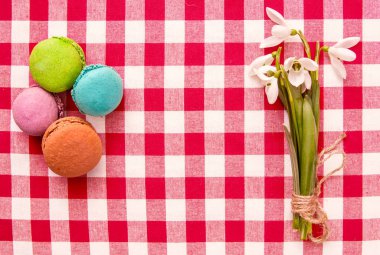 çiçekli masa örtüsü üzerinde renkli acıbadem kurabiyesi