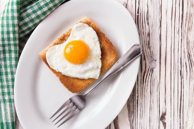 Sahanda yumurta tost bir plaka üzerinde kalp şeklinde