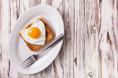 Sahanda yumurta tost bir plaka üzerinde kalp şeklinde