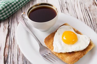 Sahanda yumurta tost bir plaka üzerinde kalp şeklinde