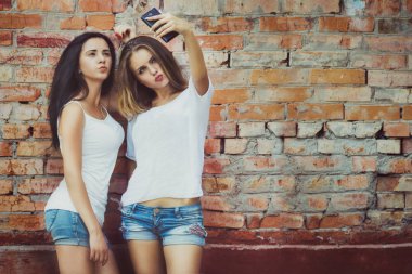 Kentsel şehir bağlamda bir selfie çekici kız. Dostluk ve yeni trendler ve teknoloji ile eğlenceli kavramı