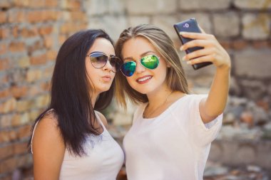 Kentsel şehir bağlamda bir selfie çekici kız. Dostluk ve yeni trendler ve teknoloji ile eğlenceli kavramı