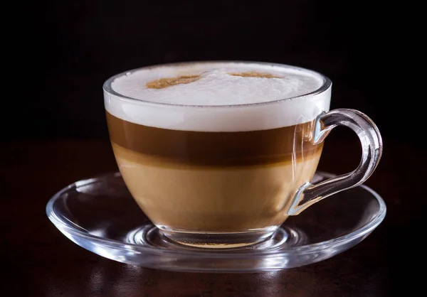 Café latte macchiato em um fundo preto — Fotografia de Stock
