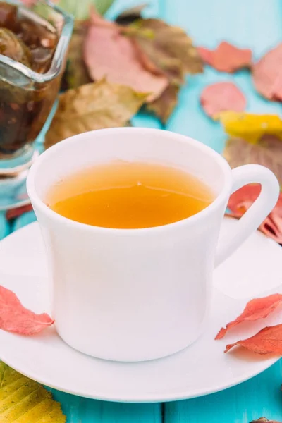 Xícara de chá na mesa com folhas caídas — Fotografia de Stock