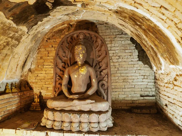 Chiang Mai, Tailandia - 05 de noviembre de 2019: Fotografía frontal de imágenes de Buda dentro de un antiguo túnel en el templo de Umong. Hay 6 pequeños Budas dorados en la parte inferior . — Foto de Stock