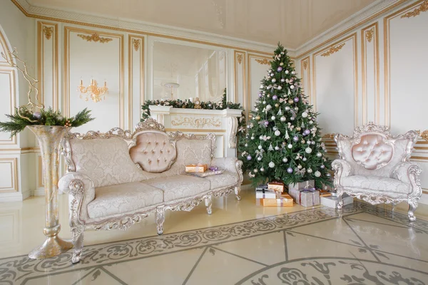 Mañana de Navidad. apartamentos clásicos con chimenea blanca, árbol decorado, sofá luminoso, grandes ventanales — Foto de Stock