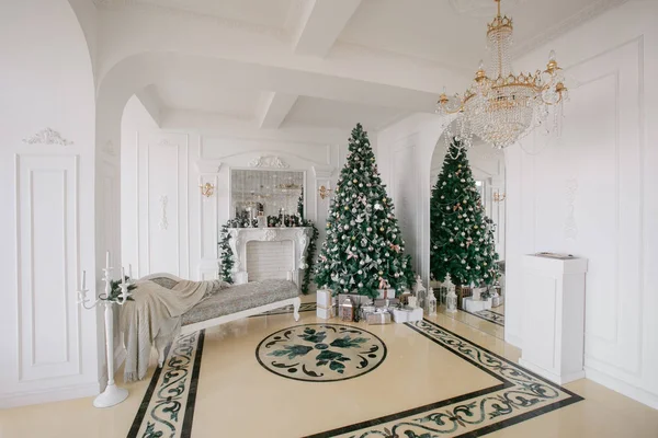 Mañana de Navidad. apartamentos de lujo clásicos con chimenea blanca, árbol decorado, sofá luminoso, grandes ventanales —  Fotos de Stock