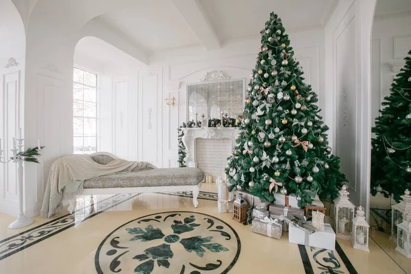 Weihnachtsmorgen. klassische Luxusappartements mit weißem Kamin, geschmücktem Baum, hellem Sofa, großen Fenstern — Stockfoto