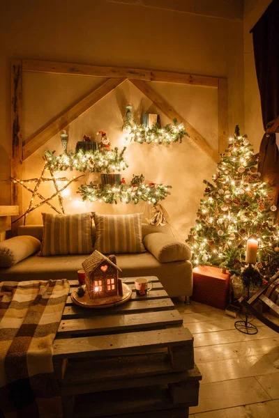 Imagen tranquila del interior de la casa moderna sala de estar decorado árbol de Navidad y regalos, sofá, mesa cubierta con manta . —  Fotos de Stock