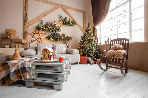 Imagen tranquila del interior de la casa moderna sala de estar decorado árbol de Navidad y regalos, sofá, mesa cubierta con manta . —  Fotos de Stock