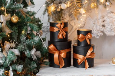 Bir masada Noel hediye olarak hediye kara kutular kurdela ile sarılmış