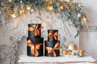 Bir masada Noel hediye olarak hediye kara kutular kurdela ile sarılmış